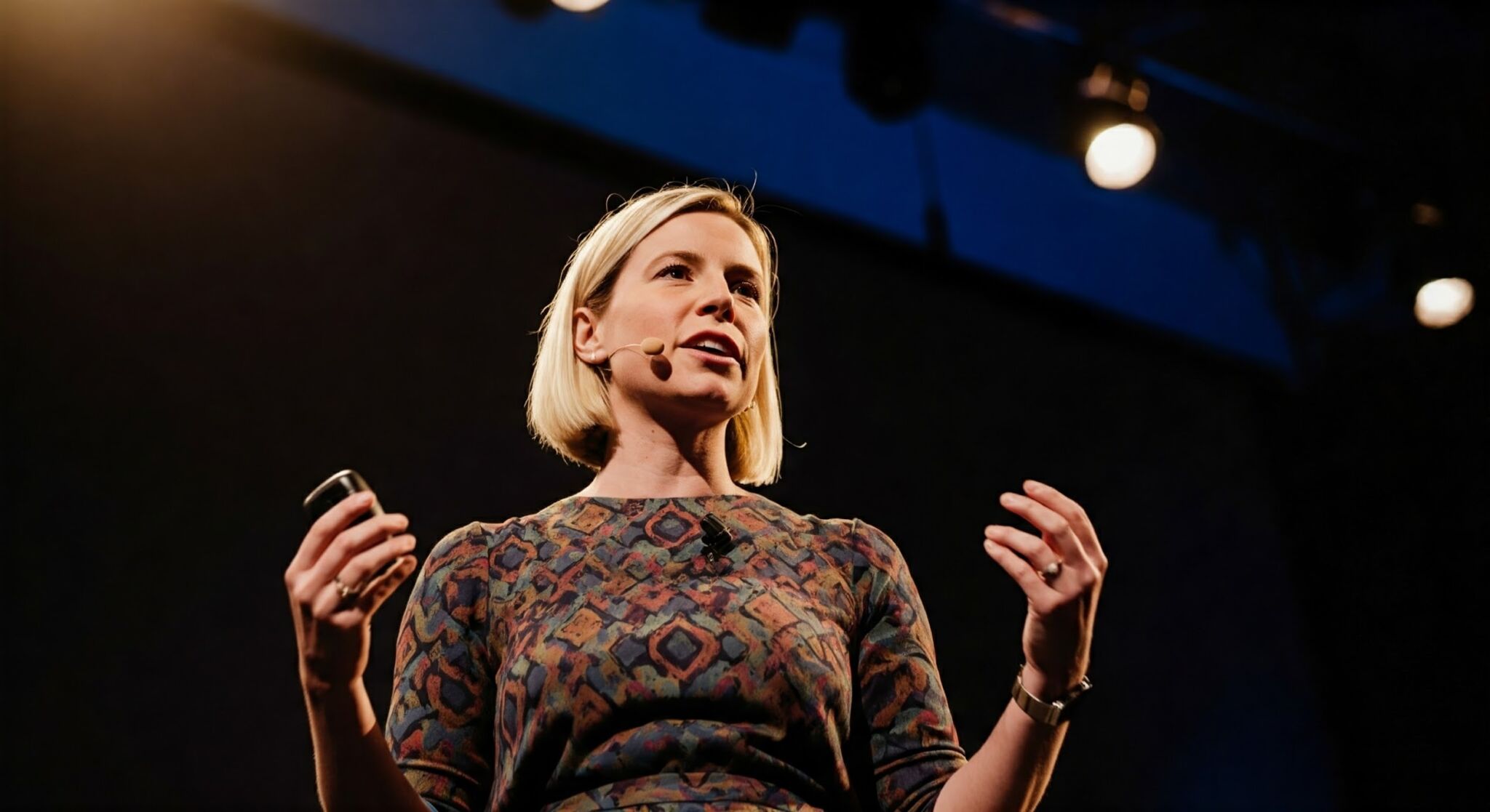Imagen generada con Gemini: "Foto de una mujer dando una charla en un escenario".