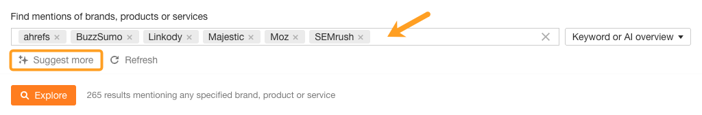 Interfaz de búsqueda de menciones de marca que muestra múltiples herramientas de SEO seleccionadas: ahrefs, BuzzSumo, Linkody, Majestic, Moz y SEMrush, devolviendo 265 resultados. Botón naranja "Explore" visible con el botón "Suggest more" resaltado con un círculo.