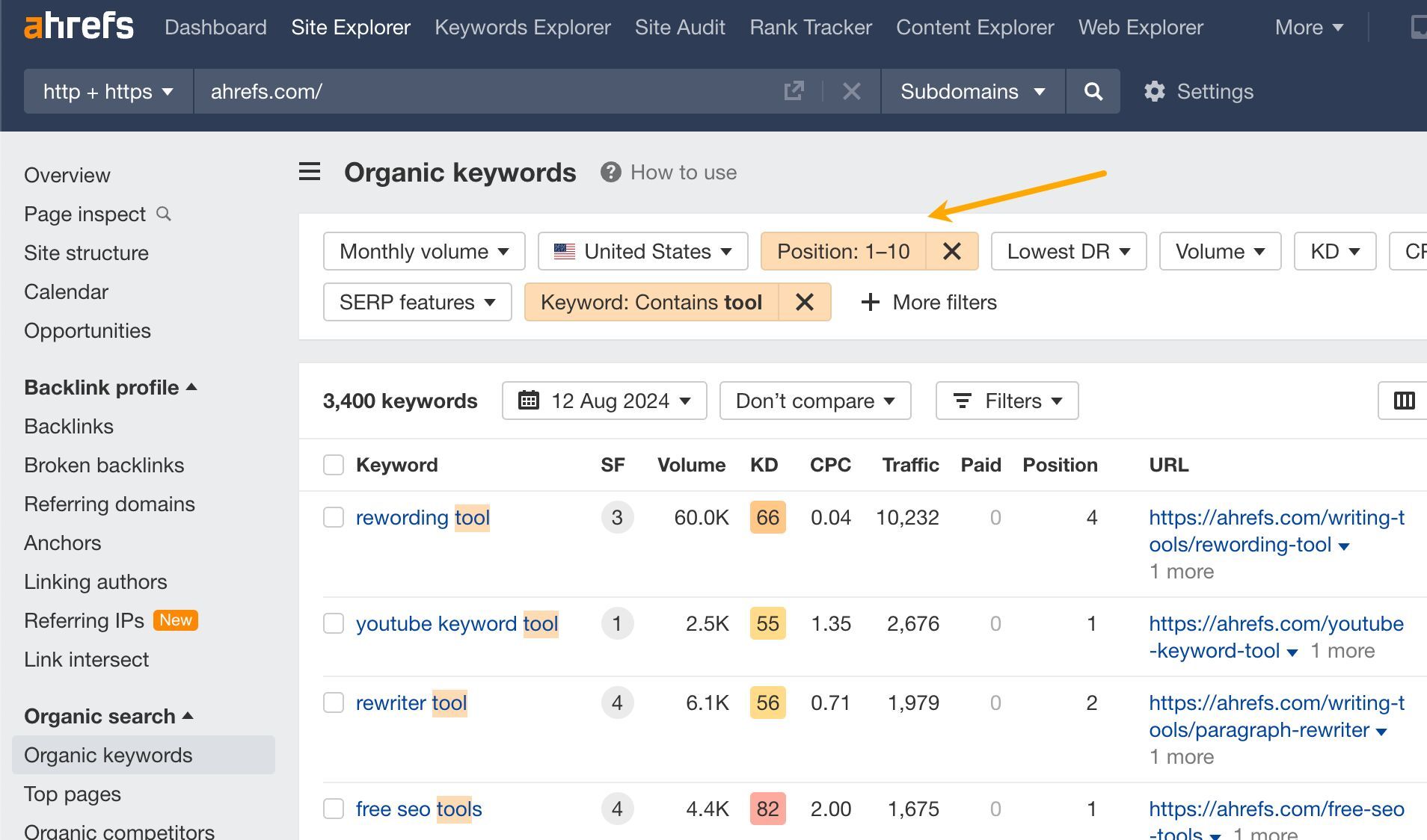 Ahrefs' "Organic keywords" showing results filtered by country, keyword contains tool, and position 1-10, as highlighted by an arrow.